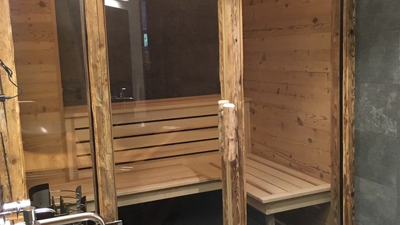 Badezimmer mit alpenländischer Design-Sauna und ebenerdiger Wellnessdusche Badezimmer mit alpenländischer Design-Sauna und ebenerdiger Wellnessdusche